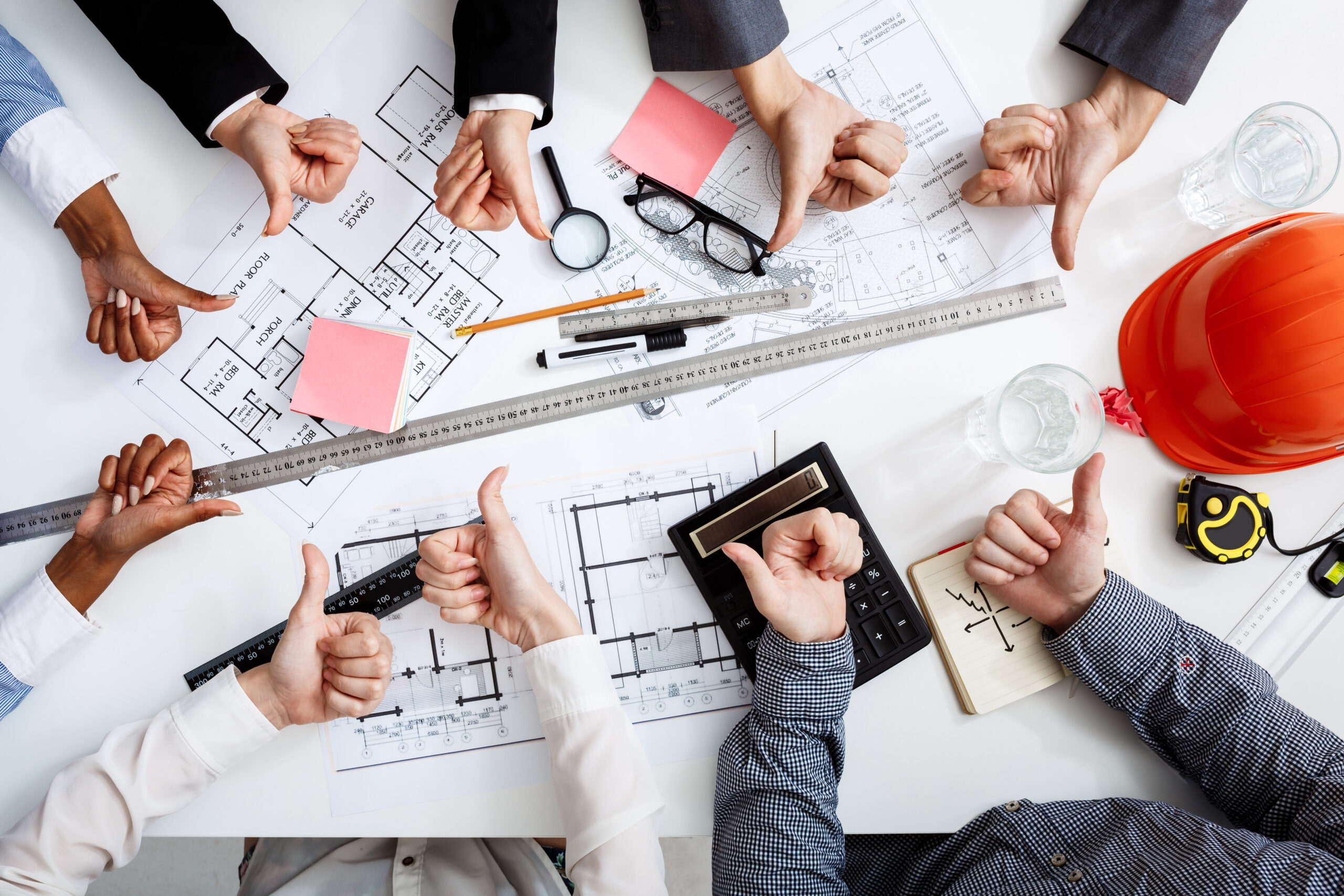 Picture of businessmen's hands on white table with documents and drafts